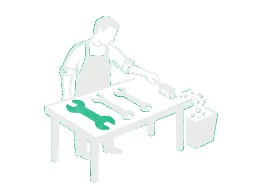 A craftsman at a workbench sweeping small trinkets into a bin, three wrenches laid in a row, the first one emerald