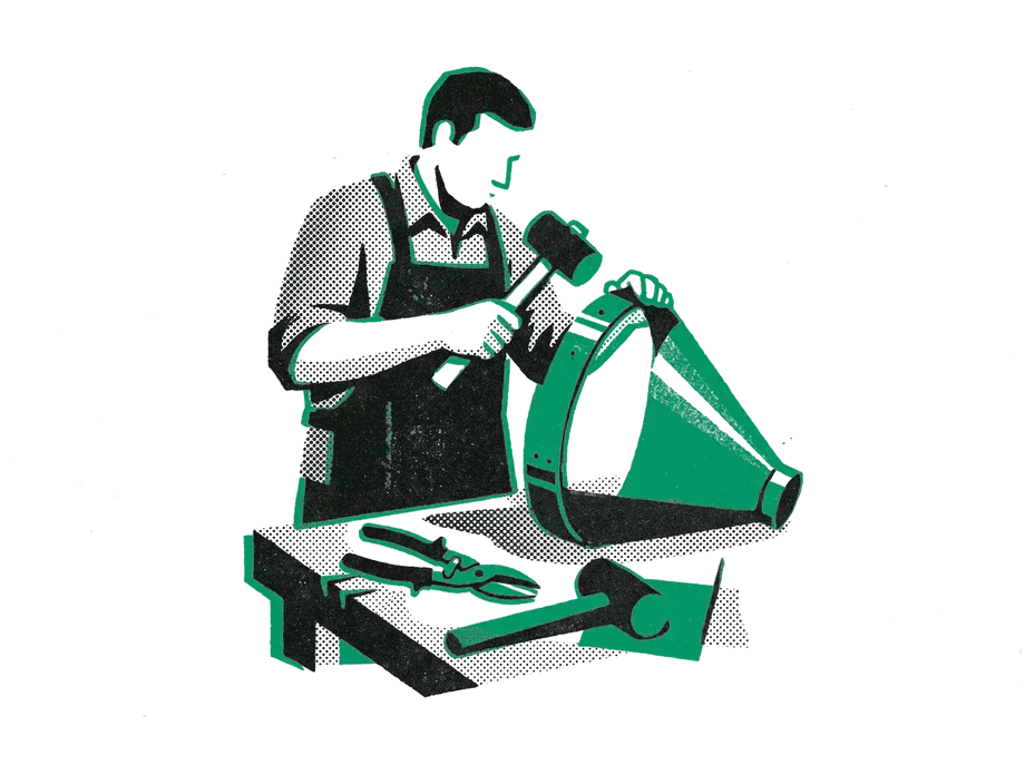 A craftsperson in an apron hammering an emerald band onto a large sheet-metal funnel at a workbench