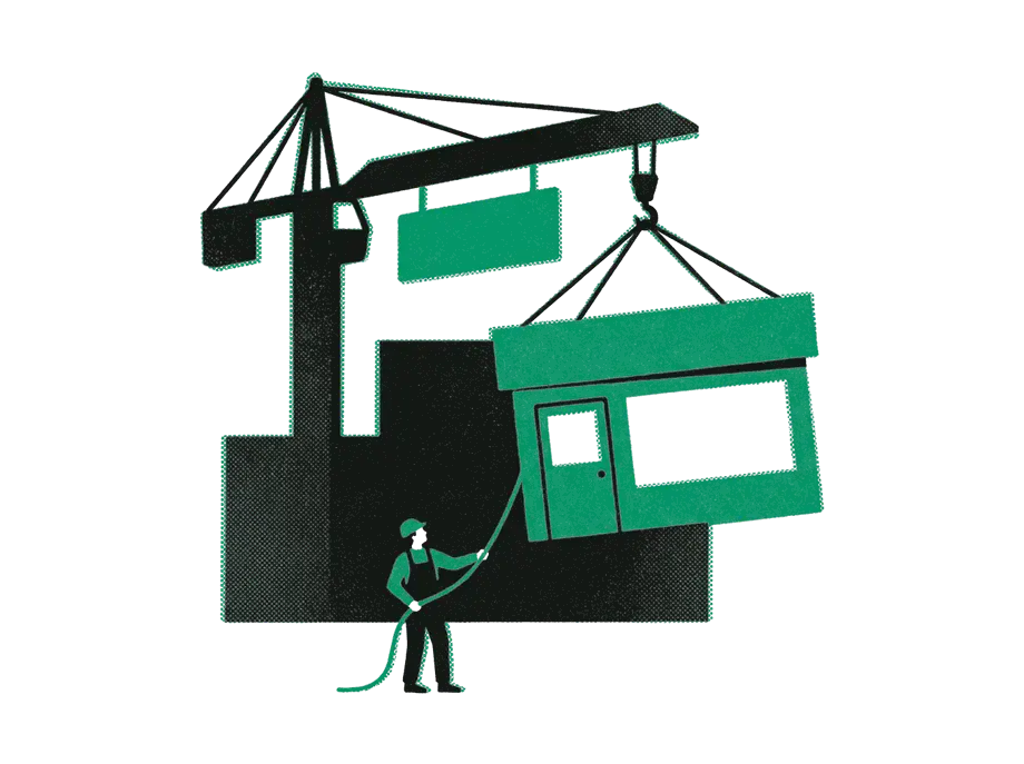 A crane lifting an emerald shopfront away from a plain black building while a worker guides it with a rope